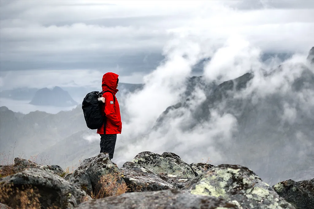 hiker wearing professional jacket ontop of a hill