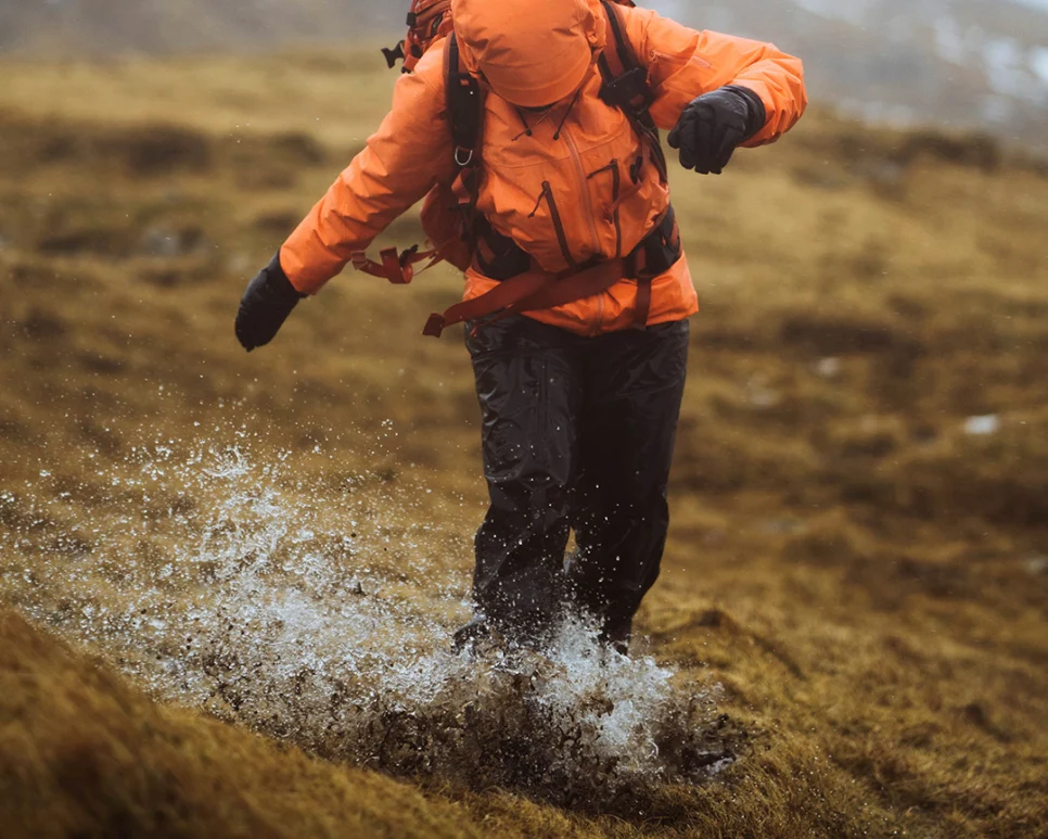 person hiking in rain with waterproofs on