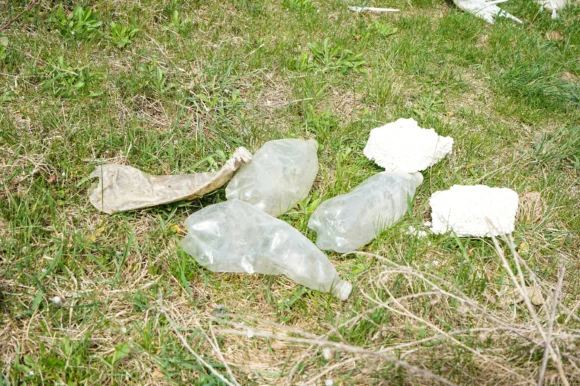 collection of bottles and rubbish left in a field